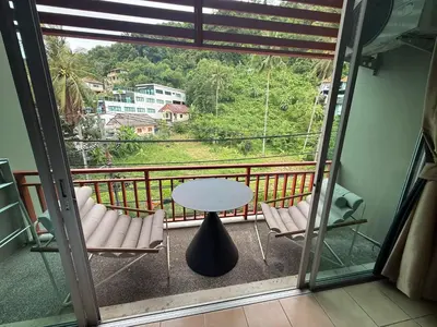 a balcony with a table and chairs and a view at Alura Guesthouse in Kata Beach