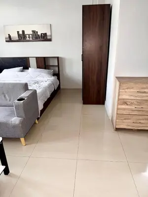 a bedroom with a bed and a chair and a door at Green Terrace Residence Phuket in Kathu