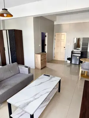 a living room with a couch and a table at Green Terrace Residence Phuket in Kathu