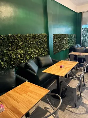 a restaurant with tables and a green wall at Green Terrace Residence Phuket in Kathu