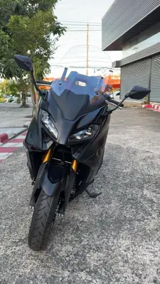 a black motorcycle parked in a parking lot at Green Terrace Residence Phuket in Kathu
