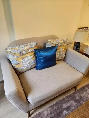 a couch with two blue pillows on it at The Base Central Phuket-B42WL in Ban Rangeng