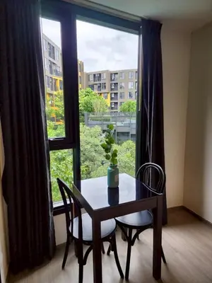 a table and chairs in a room with a large window at The Base Central Phuket-B42WL in Ban Rangeng