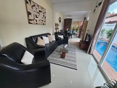 a living room with black leather furniture and a swimming pool at Cozy 3 Bedrooms Pool Villa near Nai Harn Beach in Rawai Beach