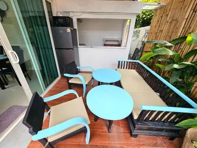a balcony with two tables and chairs and a kitchen at Cozy 3 Bedrooms Pool Villa near Nai Harn Beach in Rawai Beach