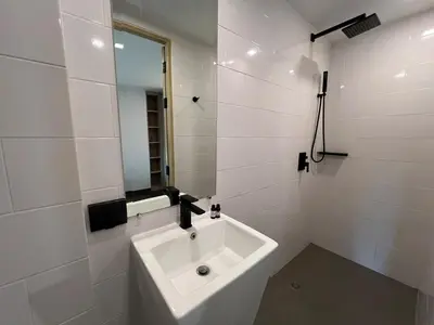 a white bathroom with a sink and a mirror at Modern Naiharn Beach Duplex Apartment in Rawai Beach