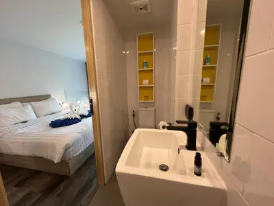 a bathroom with a sink and a bed and a tub at Modern Naiharn Beach Duplex Apartment in Rawai Beach