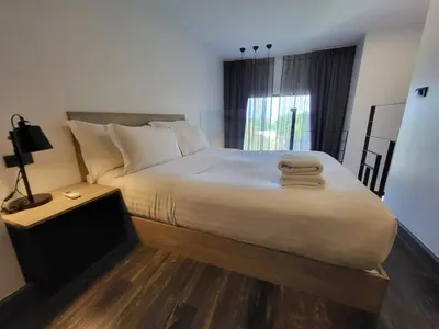 a bedroom with a large bed with towels on it at Modern Naiharn Beach Duplex Apartment in Rawai Beach