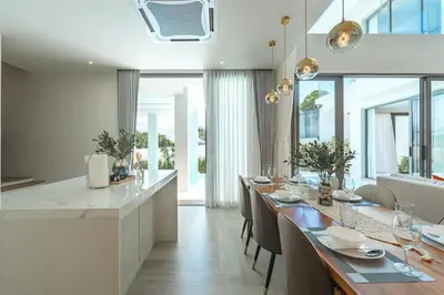 a kitchen and dining room with a long dining table at V185 New Modern Villa with Private Pool in Bang Tao Beach