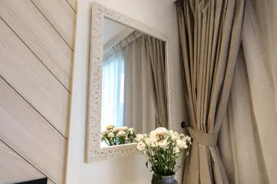 a mirror on a wall with a vase of flowers at Perfect Studio 3 pools Nai Harn in Rawai Beach
