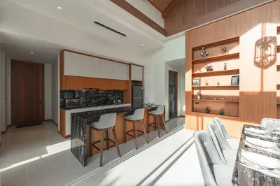 a kitchen with a bar with stools and a stove at V186 Quiet Glamour Oasis 4BR Poolside Sanctuary in Bang Tao Beach