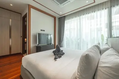 a bedroom with a bed with a stuffed animal on it at V186 Quiet Glamour Oasis 4BR Poolside Sanctuary in Bang Tao Beach
