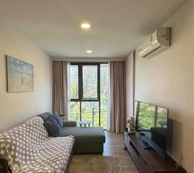 a living room with a couch and a flat screen tv at Аппартаменты Sky Park Laguna Phuket in Bang Tao Beach