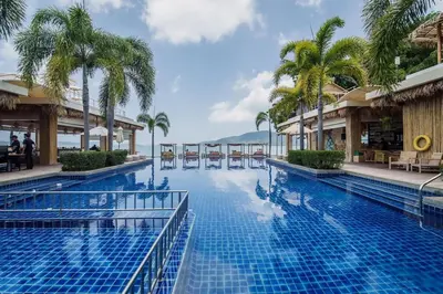 a pool at a resort with palm trees at NEW Malee Resort Studio 858 in Rawai Beach