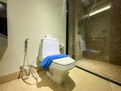 a bathroom with a toilet with a blue towel on it at NEW Malee Resort Studio 858 in Rawai Beach
