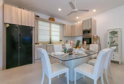 a kitchen with a table with white chairs and a kitchen with at V187 Walkable to Beach Very modern Jacuzzi pool in Rawai Beach