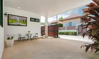 a patio with chairs and a table in a house at V187 Walkable to Beach Very modern Jacuzzi pool in Rawai Beach
