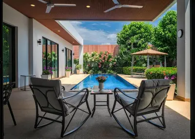 a patio with a table and chairs and a pool at V187 Walkable to Beach Very modern Jacuzzi pool in Rawai Beach