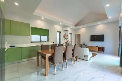 a kitchen and dining room with a table and chairs at V189 Stylish 3BR Hideaway Pool & Beach Vibes in Rawai Beach