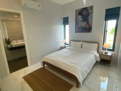 a bedroom with a large white bed and a bathroom at V189 Stylish 3BR Hideaway Pool & Beach Vibes in Rawai Beach