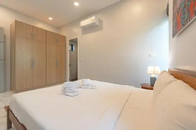 a bedroom with a white bed with towels on it at V189 Stylish 3BR Hideaway Pool & Beach Vibes in Rawai Beach