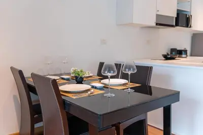 a dining room table with chairs and wine glasses at Patong private spacious apart-ment 2 minutes walk to the beach bathtub sea view swimming pool in Patong Beach