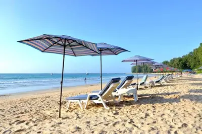a row of lounge chairs and umbrellas on a beach at B8 Ватсап669З5В2I976 in Nai Yang Beach