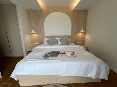 a bedroom with a large white bed with clothes on it at Fantasea Condominium Kamala in Kamala Beach