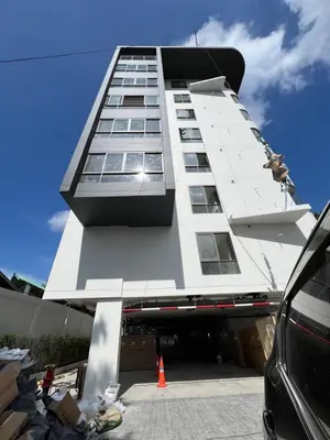 a tall white building with an orange cone in front of it at Fantasea Condominium Kamala in Kamala Beach