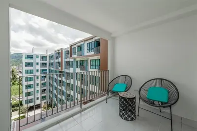 a balcony with two chairs and a view of a building at C185 Centrio 2BR Condo Walk to Mall Near Town in Phuket Town