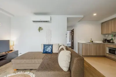 a living room with a couch and a kitchen at C185 Centrio 2BR Condo Walk to Mall Near Town in Phuket Town