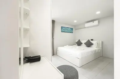 a white bedroom with a white bed and a mirror at V192 Brand New Golf side 5BR Villa with Private Pool in Kathu