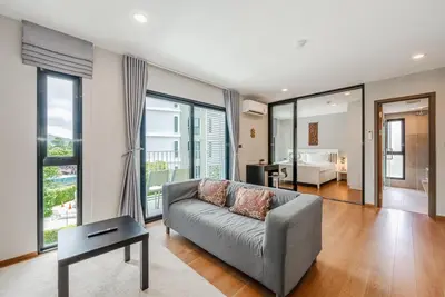 a living room with a couch and a bedroom at C188 Modern Condo Pool Gym & Walk to Rawai Beach in Rawai Beach