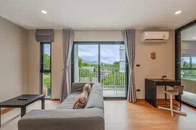 a living room with a couch and a large window at C188 Modern Condo Pool Gym & Walk to Rawai Beach in Rawai Beach