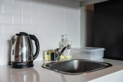 a kitchen counter with a sink and a tea kettle at C188 Modern Condo Pool Gym & Walk to Rawai Beach in Rawai Beach