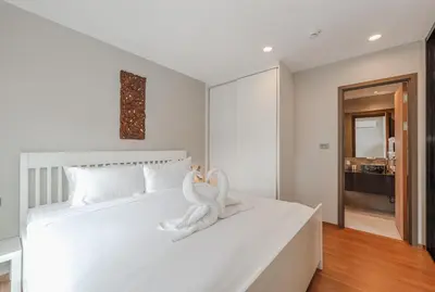 a white bed with a towel animal sitting on it at C188 Modern Condo Pool Gym & Walk to Rawai Beach in Rawai Beach
