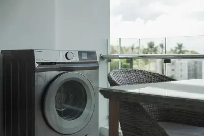 a washing machine sitting on a balcony with a table at C189 Beachside Luxury in Rawai Sea View and Gym in Rawai Beach