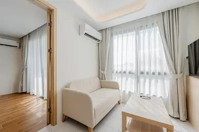 a living room with a white couch and a table at C190 Sleek 1BR with Infinity Pool, Gym, Rooftop in Kamala Beach