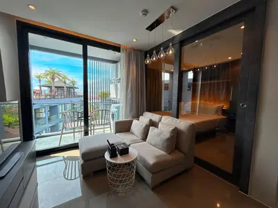 a living room with a couch and a view of a balcony at C191 CityGate Kamala Stylish Stay by Pools and Gym in Kamala Beach