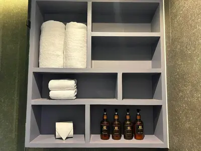 a bathroom cabinet with towels and bottles of alcohol at C191 CityGate Kamala Stylish Stay by Pools and Gym in Kamala Beach