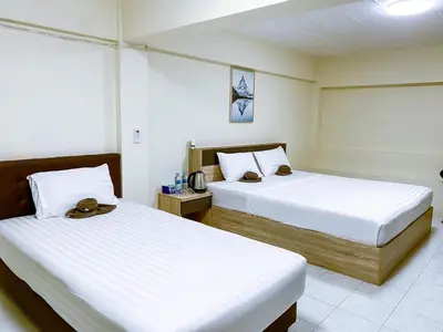 two beds in a hotel room with two beds at ANK Residence Patong in Patong Beach