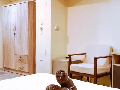 a room with a bed and a chair and a table at ANK Residence Patong in Patong Beach