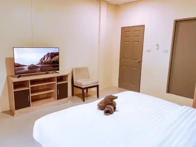 a bedroom with a bed and a tv and a chair at ANK Residence Patong in Patong Beach