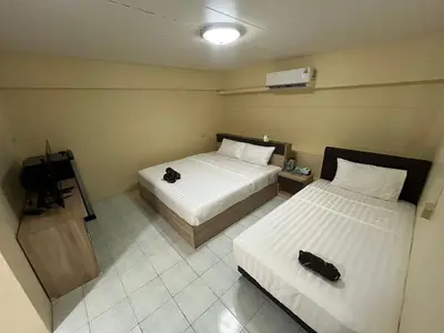 a hotel room with two beds and a television at ANK Residence Patong in Patong Beach