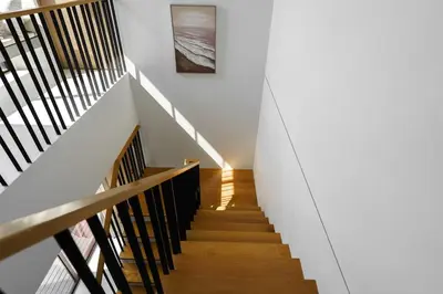 a staircase in a house with white walls and wooden floors at Modern 3 Bdr Villa Tree O'Clock Bangtao With a Pool in Ban Pak Lak