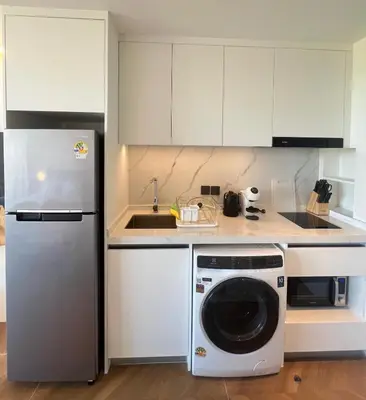 a kitchen with a refrigerator and a washing machine at Sunshine Beach Residence Resort in Phuket Town