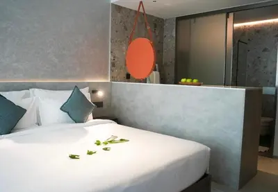 a bedroom with a large white bed with leaves on it at Sunshine Beach Residence Resort in Phuket Town