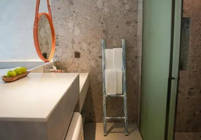 a bathroom with a mirror and a towel rack at Sunshine Beach Residence Resort in Phuket Town