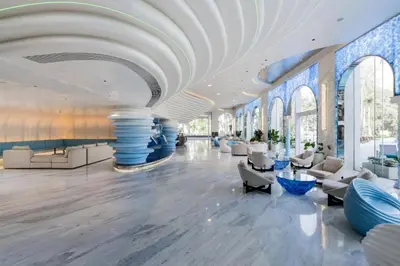 a lobby with white furniture and a white ceiling at Sunshine Beach Residence Resort in Phuket Town