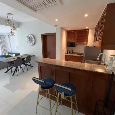 a kitchen and dining room with a counter and stools at Allamanda 3 Laguna Phuket by Star in Laguna Phuket